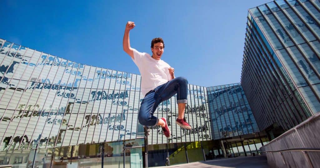 Student at university jumping in celebration