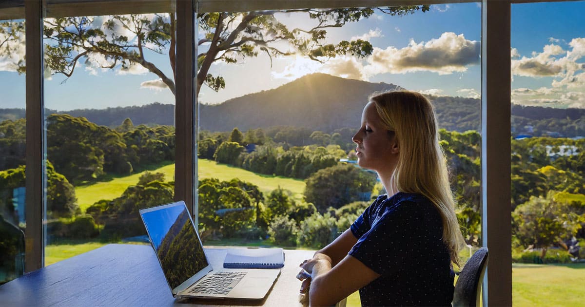 University student with bush views from home office