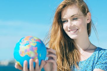 Woman smiling while holding world globe