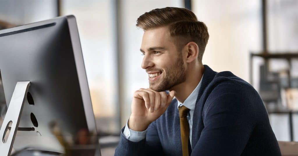 Young man watching computer monitor